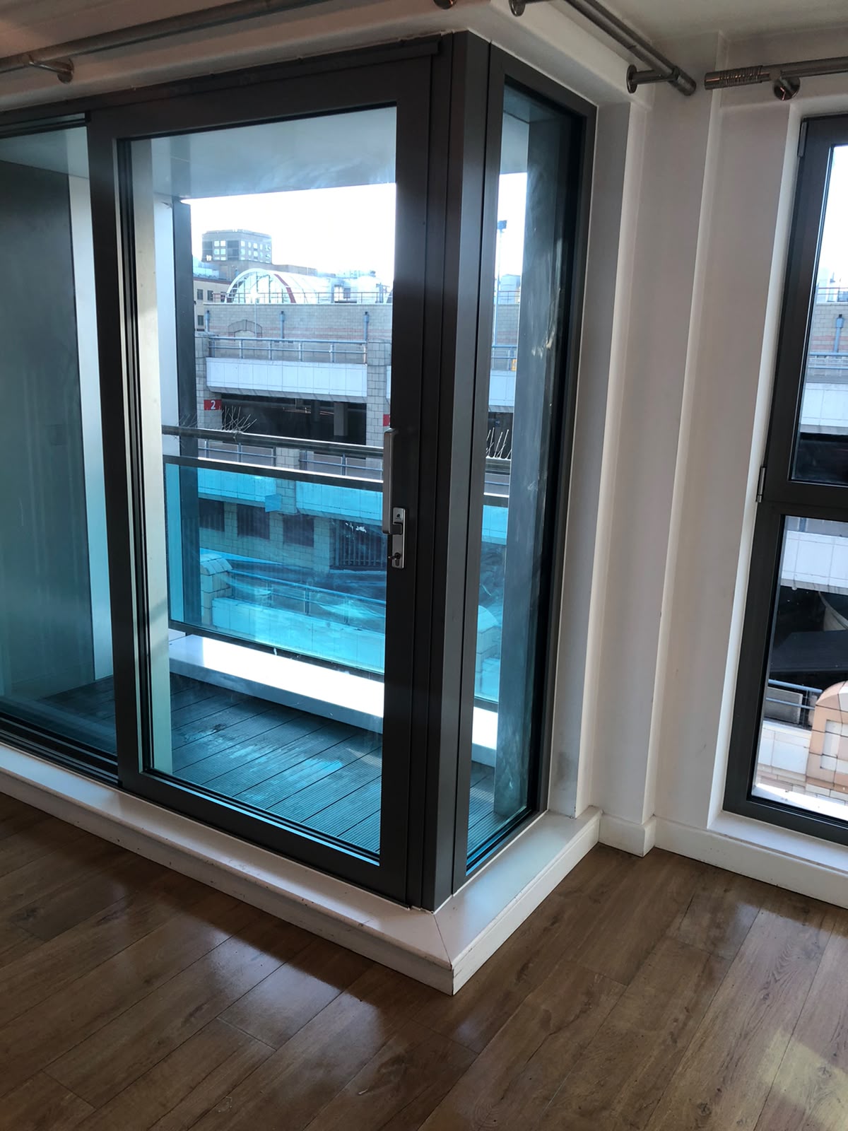Clean, fresh room with balcony doors and wood flooring
